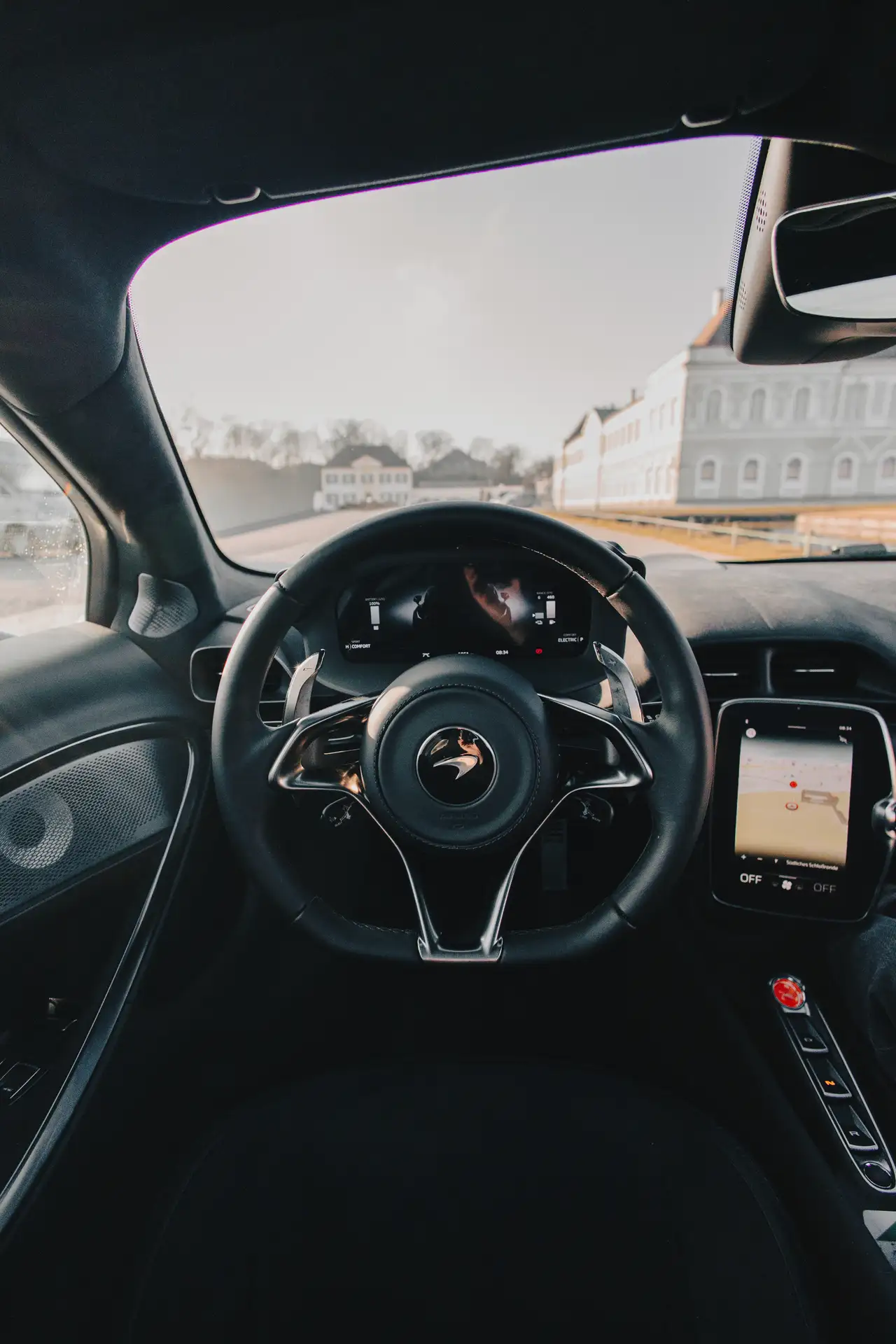 Lenkrad von dem McLaren Atura Spider vor einem historischen Schlossgebäude